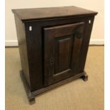 An 18th Century Dutch oak dwarf cupboard, the fielded panelled door enclosing a single shelf, raised