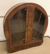 A 1930's walnut veneered Art Deco style sunburst display cabinet with two doors enclosing glass