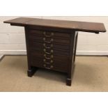 A Victorian mahogany artist's chest, the drop leaf top over seven long drawers with brass swan