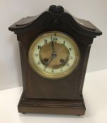 An early 20th Century mahogany and inlaid mantel clock, the dial set with Roman numerals with French