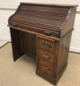 An early 20th Century oak single pedestal tambour top desk, 91 cm wide x 49 cm deep x 105 cm high,