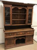 A late Victorian pine dresser with two glazed doors and three shelves over three drawers, a
