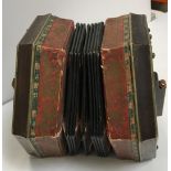 A twenty-one button unnamed rosewood concertina with decorated paper bellows together with a further