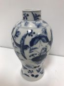 A 19th Century Kangxi baluster vase with blue and white floral spray and bird decoration, bears four