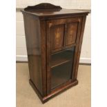 A late Victorian rosewood and marquetry inlaid music cabinet, the part glazed door enclosing four