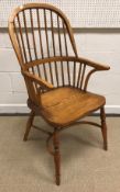 A modern oak Thames Valley style stick back elbow chair with shaped seat on turned supports united