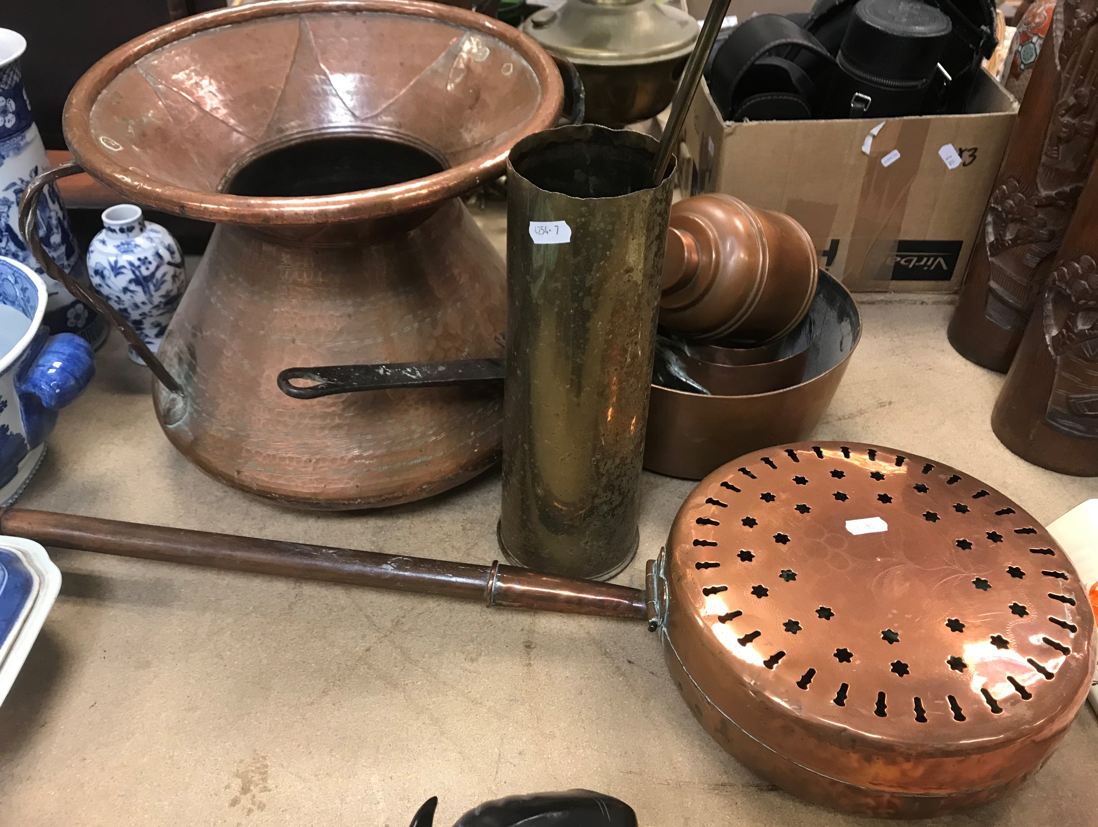 A large Middle Eastern style two handled copper pot with flared rim 28.5 cm high, a brass shell case