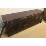 A modern Chinese rosewood sideboard, the plain top above two banks of cupboard doors flanking a