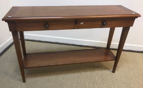 A modern cherrywood two-drawer side table on square tapered legs united by an under-tier (124.5 cm W