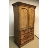 A Victorian mahogany linen press, the moulded cornice over two arched panelled doors enclosing