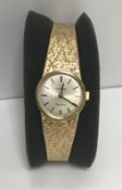 A ladies 9 carat gold cased Omega wristwatch, the dial set with numeral markers and bark textured