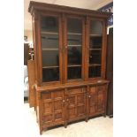 A Victorian oak and burr oak bookcase cabinet, the upper section with three glazed doors over a