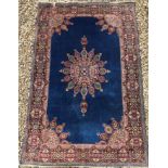 A Persian rug, the central panel set with floral decorated medallion on a blue ground, with floral