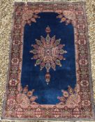 A Persian rug, the central panel set with floral decorated medallion on a blue ground, with floral