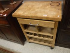 A modern butchers block type kitchen table with single drawer over a shelf, wine rack and further