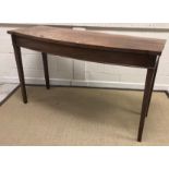 A 19th Century mahogany shallow bow fronted serving table, the plain top above a plain frieze