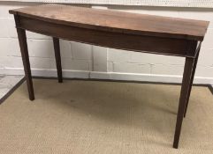 A 19th Century mahogany shallow bow fronted serving table, the plain top above a plain frieze