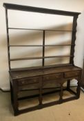 A 19th Century oak dresser, the four tier open plate rack over three drawers on flat baluster shaped