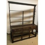 A 19th Century oak dresser, the four tier open plate rack over three drawers on flat baluster shaped