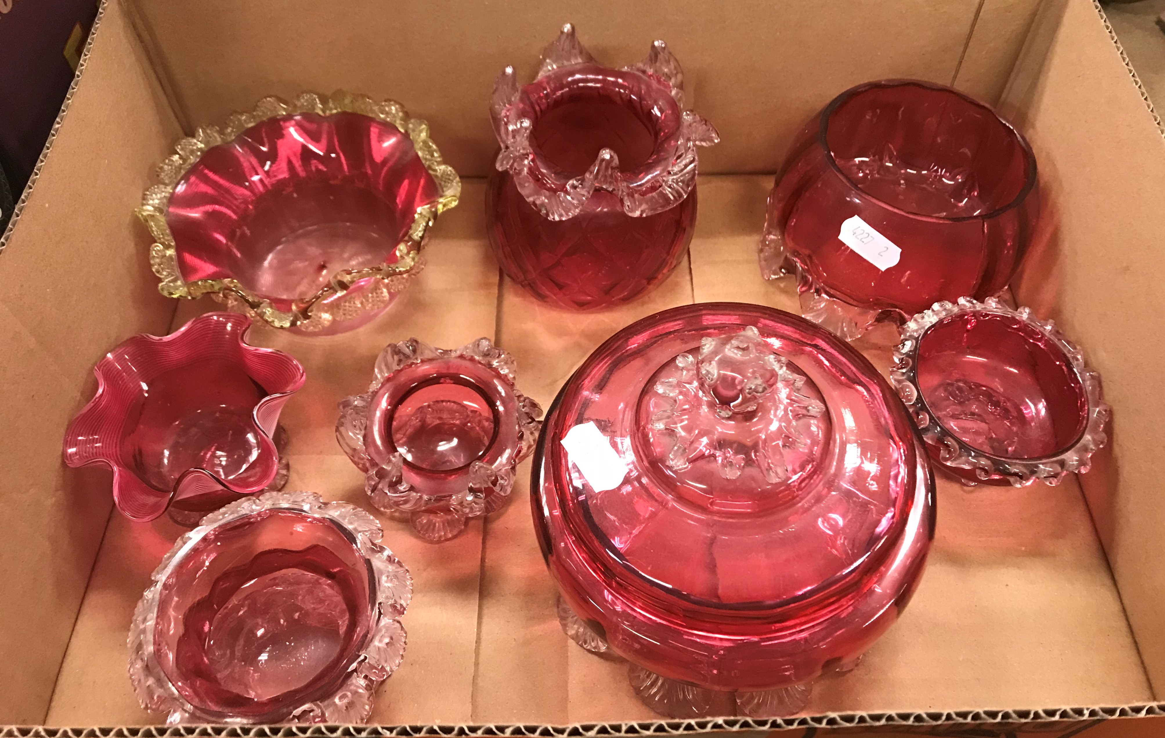 A collection of Cranberry glass to include lidded bowl, two lidded jars, two jugs, a basket etc