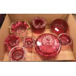 A collection of Cranberry glass to include lidded bowl, two lidded jars, two jugs, a basket etc