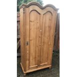 A 20th Century pine wardrobe in the 18th Century French style with double dome top above a single