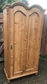 A 20th Century pine wardrobe in the 18th Century French style with double dome top above a single