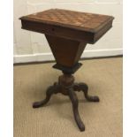 A Victorian walnut and parquetry inlaid games top sewing table on turned column support to carved