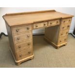 A pine dressing table / pedestal desk, the plain top with galleried back, raised on two banks of
