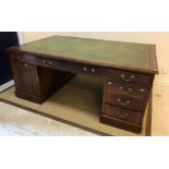 An Edwardian mahogany partners' desk, the plain top with leather insert writing surface, over two