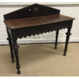 A late Victorian Gothic style side table with raised back on carved egg and dart and wrythen tapered