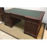 A modern mahogany partners' desk, the top with leatherette insert above a base with reeded column