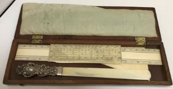 A silver mounted ivory page turner 27 cm long together with an ivory rule a foot long etc housed