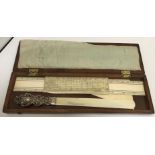 A silver mounted ivory page turner 27 cm long together with an ivory rule a foot long etc housed