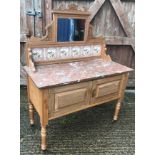 A late Victorian satin walnut washstand with mirrored and tiled back over a marble top and two