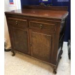 An early 20th Century burr walnut side cabinet with shallow raised back over two drawers and two