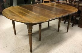 An OKA stained pine D end drop-leaf dining table on turned and ringed supports,