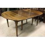 An OKA stained pine D end drop-leaf dining table on turned and ringed supports,
