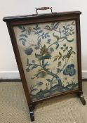 A circa 1900 rosewood framed fire screen with silk needlework panel of stag and blossoming tree, 55.