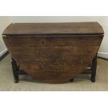 An 18th Century oak oval gate-leg drop-leaf dining table on turned and block supports to splayed