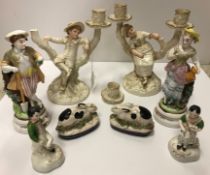 A pair of Royal Worcester figural candlesticks designed by James Hadley as "Boy and girl reclining