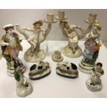 A pair of Royal Worcester figural candlesticks designed by James Hadley as "Boy and girl reclining