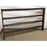 A circa 1800 oak three tier open plate rack with fretwork carved friezes to the shelves,