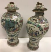 A pair of 19th Century Chinese famille rose polychrome decorated baluster shaped vases with panels