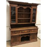 A late Victorian pine dresser with two glazed doors and three shelves over three drawers,