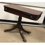 A Regency mahogany and rosewood inlaid fold-over tea table on turned and ringed centre pedestal to