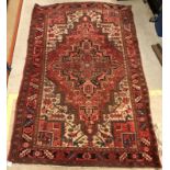 A Herez rug, the central panel set with central starburst motif on a red ground,