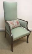 An Edwardian mahogany and satinwood strung high back armchair on sabre front legs,