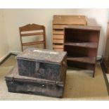 Two tin trunks, an open bookcase,