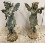 A cast iron figure of a fairy with shell in her hand and another with bird in her hand,